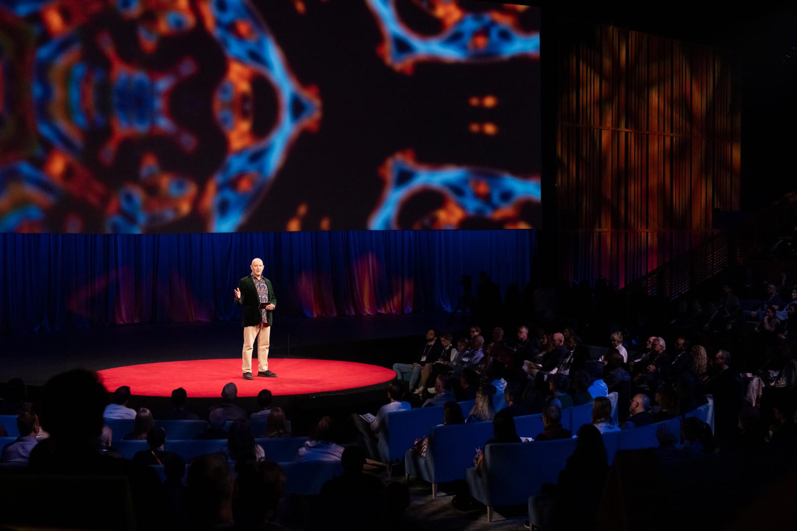 Julian Treasure on the red circle of the TED stage, facing a full theatre