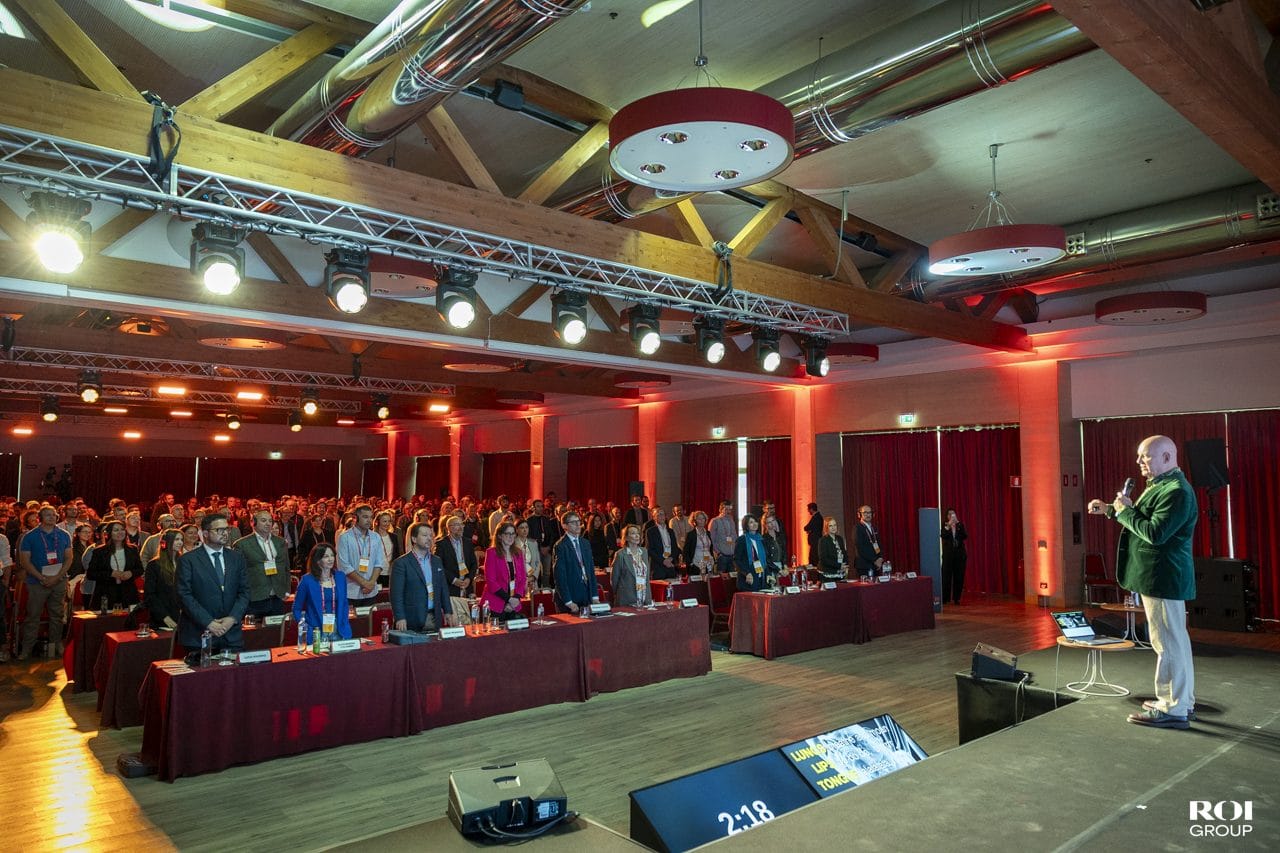 A wide view of a large hall full of delegates, with Julian Treasure speaking at the front