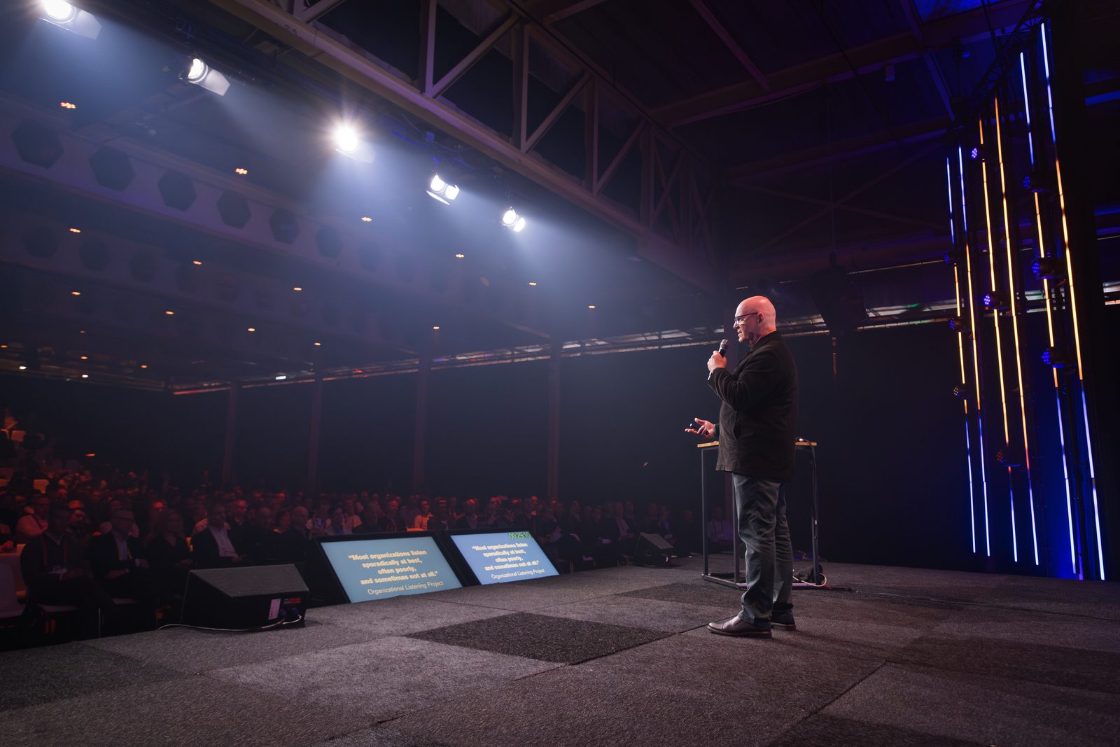 Julian Treasure on stage under spotlights, speaking to a large audience in a hall, Rotterdam